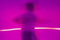 a blurry image of a person running in front of a purple light